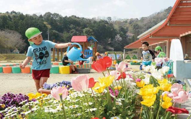 幼児が花に水やりをしている写真