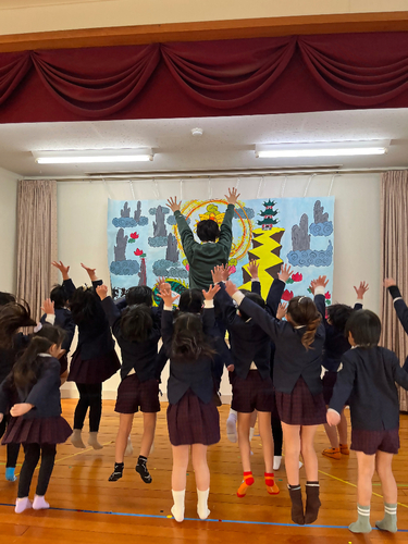 写真　保育士とこどもがホールで遊んでいる。