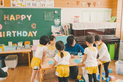 写真　大川幼稚園のお部屋で遊ぶ園児と保育士