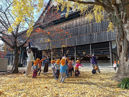 写真　高田幼稚園の園庭で遊ぶ園児と保育士