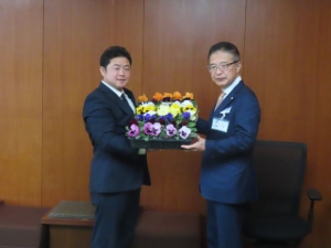写真:有限会社亀井園芸 亀井健一代表取締役よりパンジーの花苗寄附贈呈式の様子