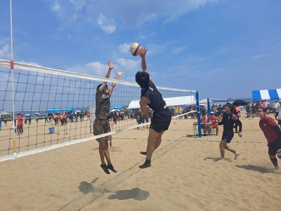 砂浜でビーチバレーをしている写真