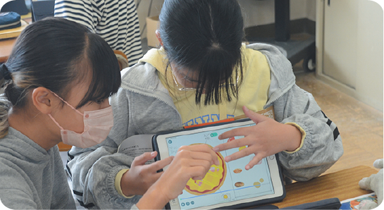 小学生がタブレットを使って学ぶ様子