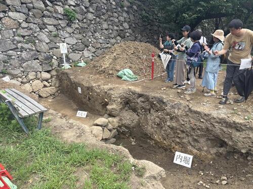 写真:西側の調査坑と写真を撮る参加者