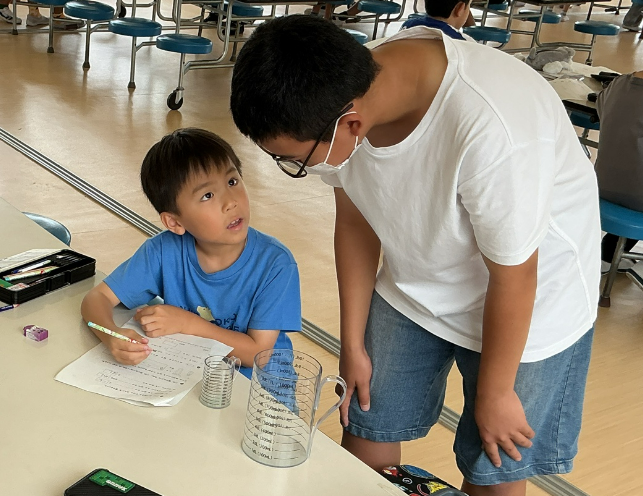 上級生に算数の考え方を聞いている児童